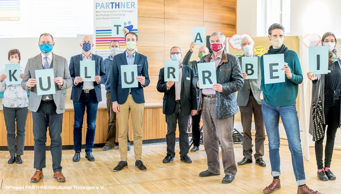 Straze Greifswald: ein hell erleuchterer und geschmückter Saal mit Menschen